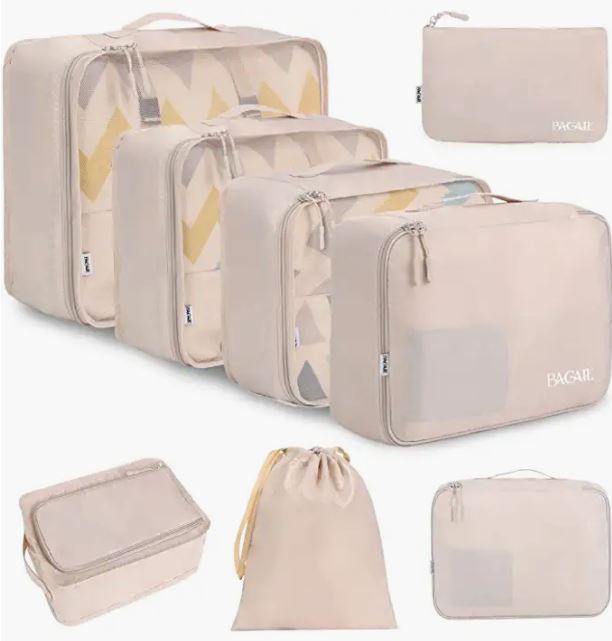 Set of eight beige and chevron-print packing cubes in graduated sizes including compression cubes, a flat organizer, drawstring shoe bag, and toiletry pouch