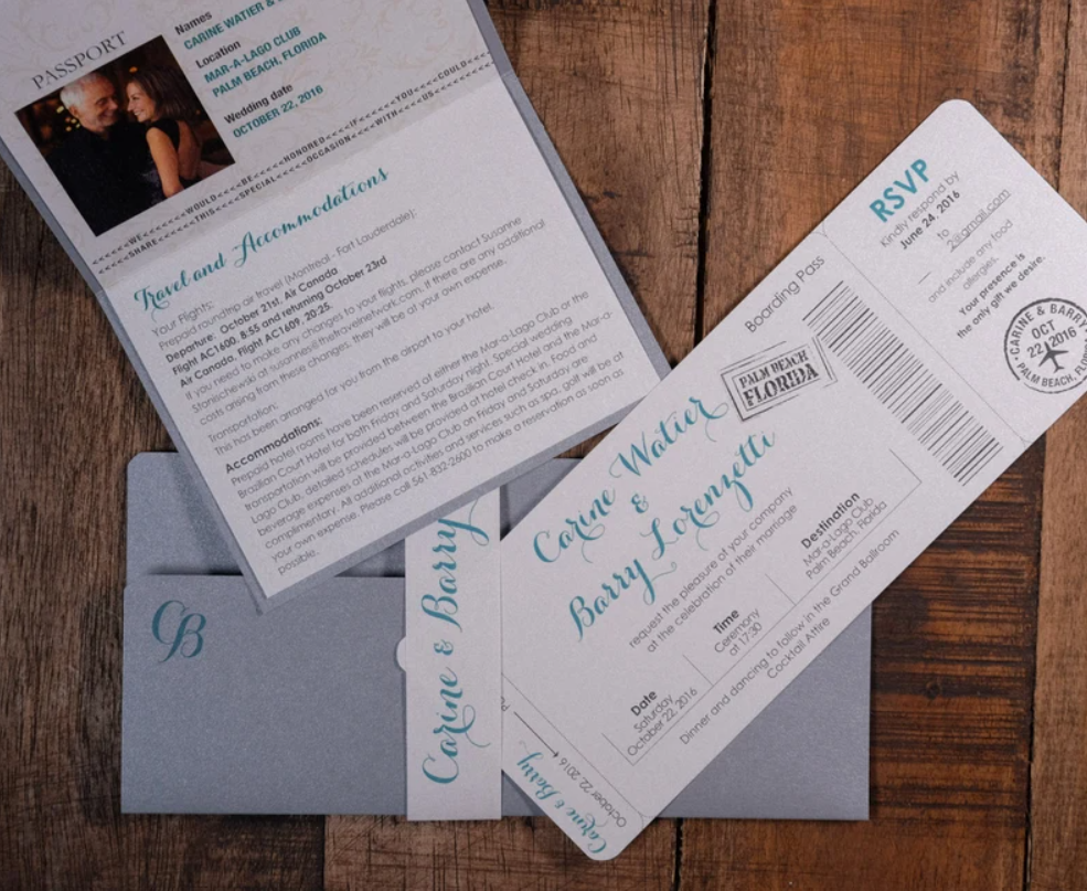 Printed boarding pass-style destination wedding invitations with gray envelopes laid on a wood surface, personalized with couple's photo and resort details